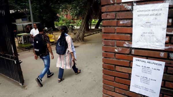 Students walk past a notice put on the art faculty